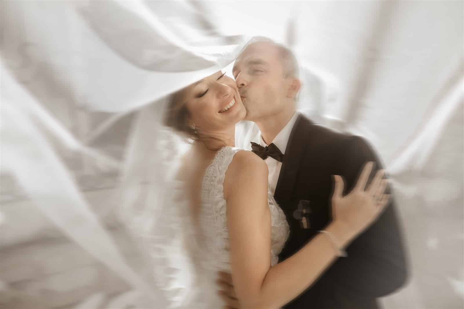 Abrazo de novios bajo el velo